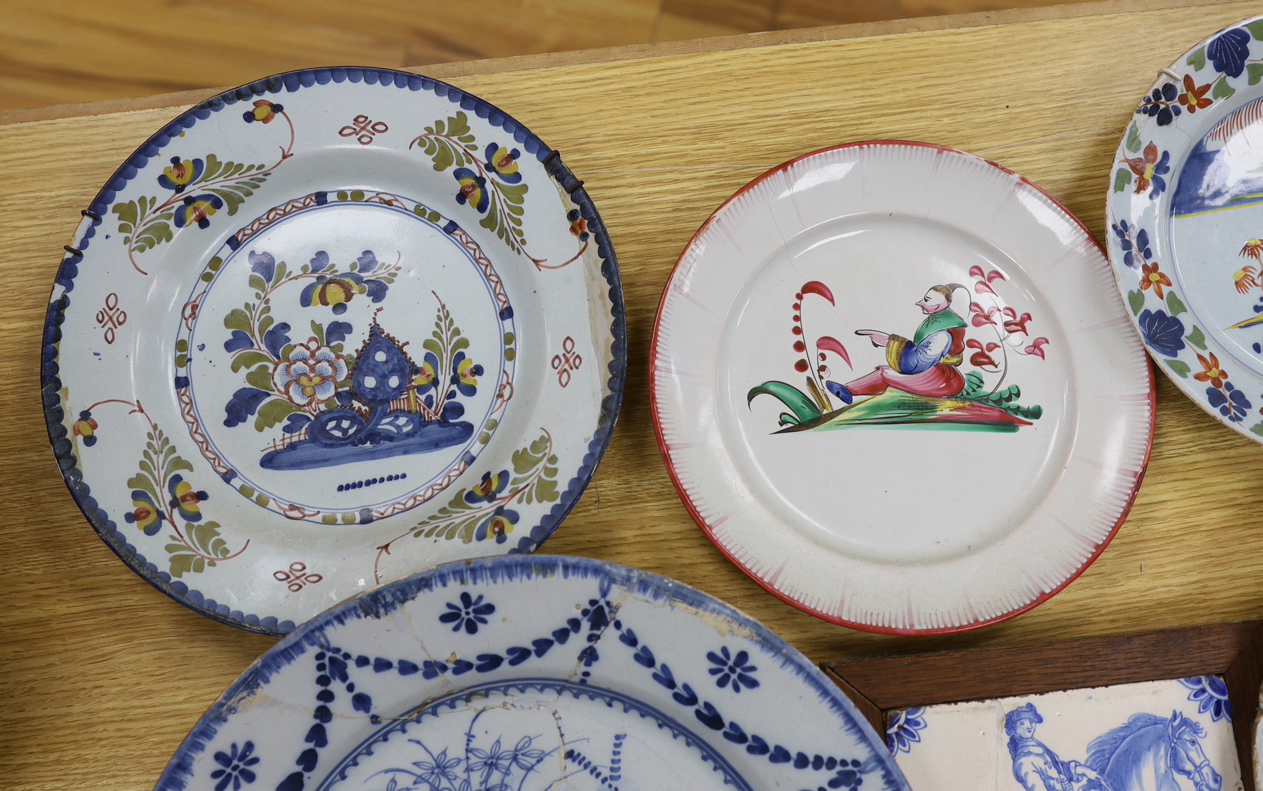 Two 18th century Delft blue and white dishes, a Delft polychrome dish, an English delftware plate, a Delft equestrian tile and a French faience plate, a.f., largest diameter 35cm